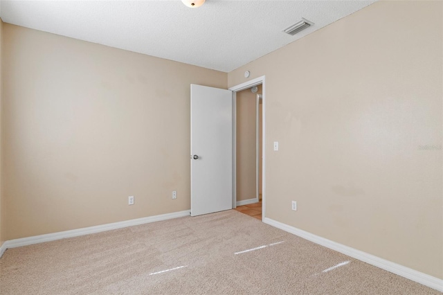 carpeted spare room featuring a textured ceiling