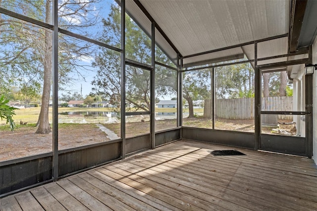 unfurnished sunroom with a water view, a healthy amount of sunlight, and lofted ceiling