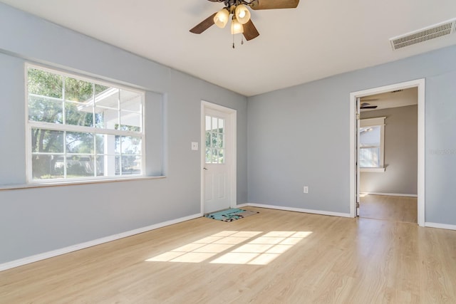 unfurnished room featuring plenty of natural light, ceiling fan, and light hardwood / wood-style flooring