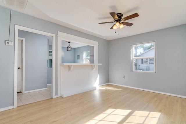 unfurnished living room featuring ceiling fan and light wood-type flooring