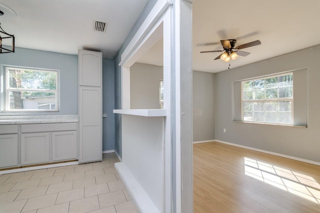 interior space with white cabinetry and ceiling fan