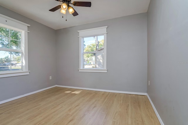 empty room featuring ceiling fan, plenty of natural light, and light hardwood / wood-style flooring