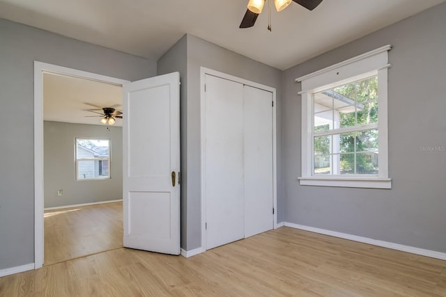 unfurnished bedroom with light hardwood / wood-style floors, a closet, and ceiling fan