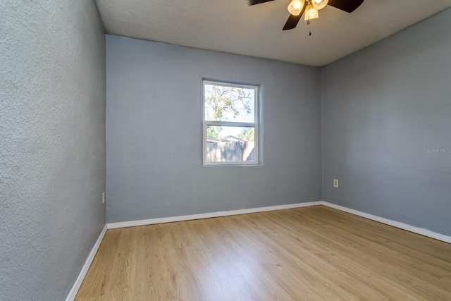 spare room with ceiling fan and light wood-type flooring