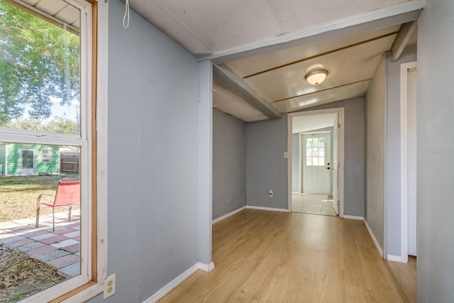 hallway featuring lofted ceiling and light wood-type flooring