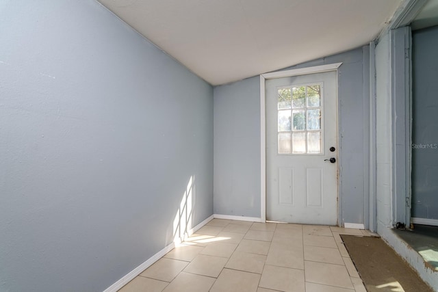 entryway featuring light tile patterned floors and vaulted ceiling