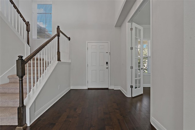 entrance foyer featuring a towering ceiling and dark hardwood / wood-style flooring