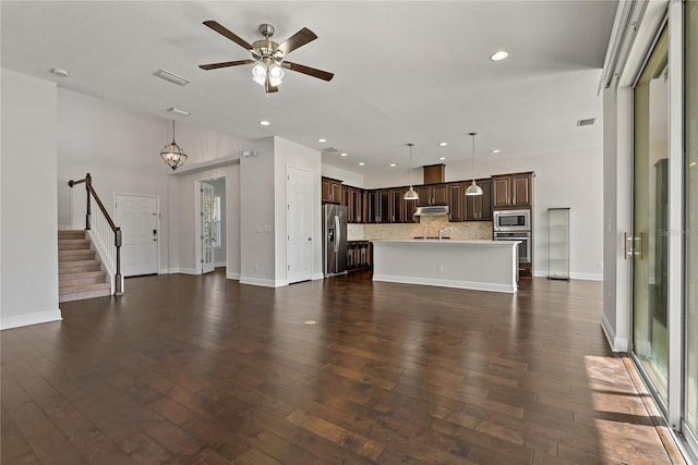 unfurnished living room with ceiling fan and dark hardwood / wood-style floors