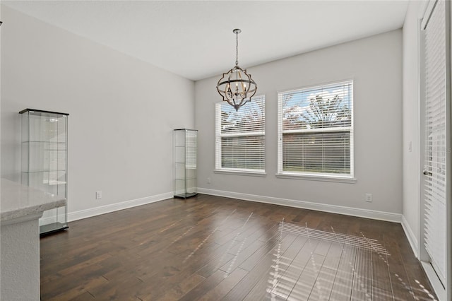 unfurnished dining area featuring dark hardwood / wood-style floors and a notable chandelier