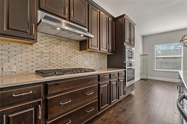 kitchen with dark brown cabinetry, appliances with stainless steel finishes, dark hardwood / wood-style floors, and backsplash