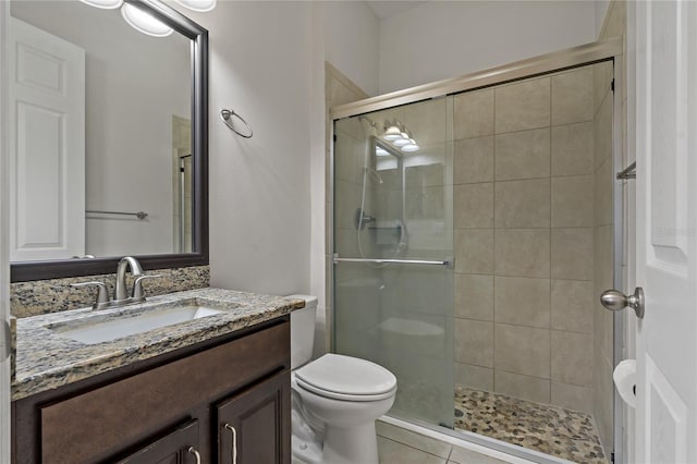 bathroom featuring vanity, toilet, an enclosed shower, and tile patterned flooring