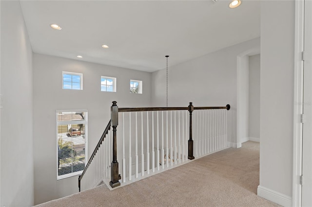 hallway featuring plenty of natural light and light colored carpet