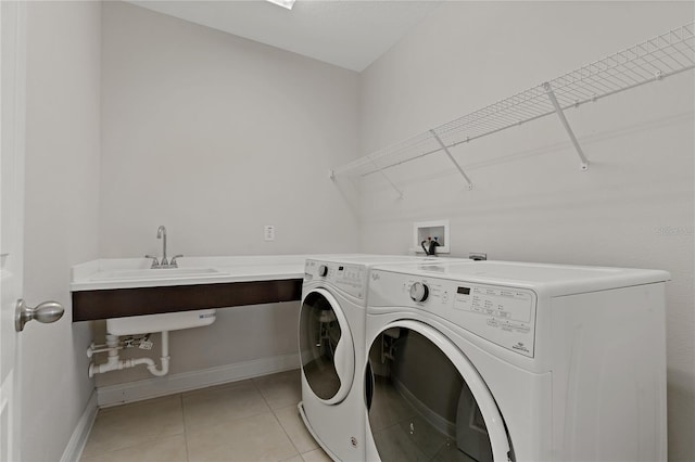 laundry room with sink, light tile patterned floors, and washing machine and clothes dryer