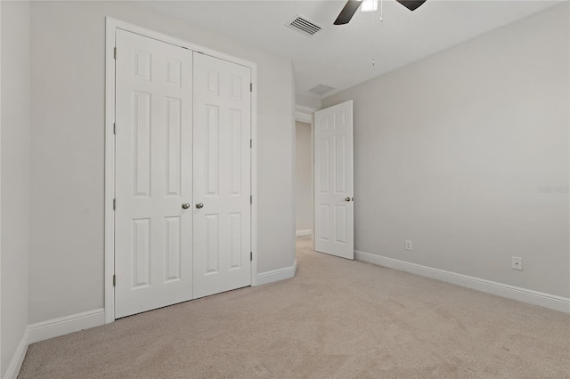 unfurnished bedroom with light carpet, ceiling fan, and a closet