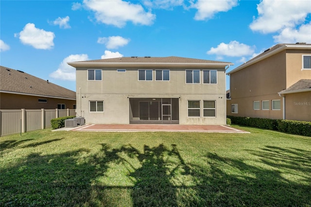 back of property featuring a yard, central AC unit, and a patio