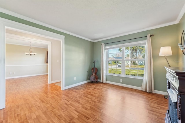 unfurnished room featuring crown molding, an inviting chandelier, and light hardwood / wood-style floors