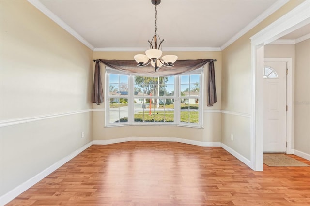 unfurnished dining area featuring crown molding, a notable chandelier, and light wood-type flooring