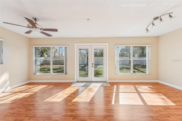 interior space featuring light hardwood / wood-style flooring, a wealth of natural light, ceiling fan, and french doors