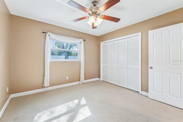 unfurnished bedroom featuring ceiling fan, a closet, and light carpet