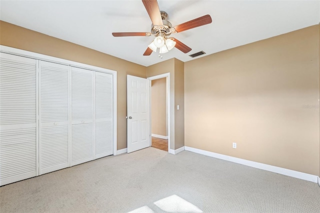 unfurnished bedroom with light carpet, ceiling fan, and a closet