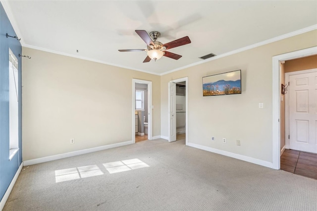 empty room with crown molding, ceiling fan, and light carpet