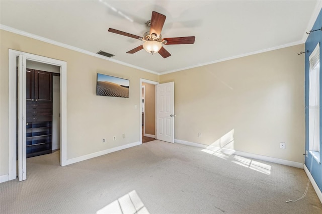 unfurnished bedroom featuring crown molding, light colored carpet, and ceiling fan