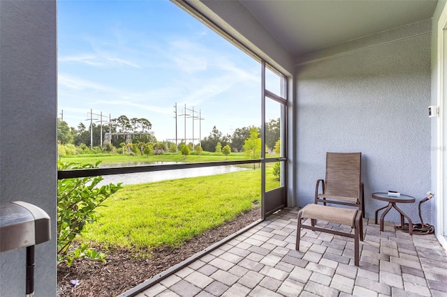 sunroom / solarium featuring a water view