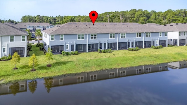 rear view of house featuring a yard and a water view