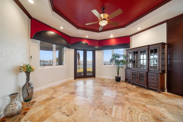 foyer with french doors, crown molding, ceiling fan, and a tray ceiling