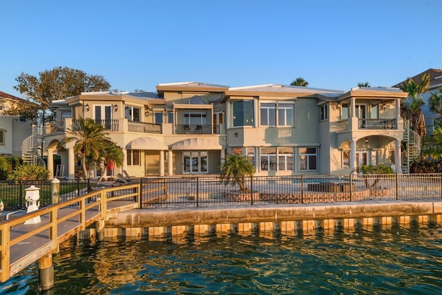 rear view of house with a fenced in pool and a water view