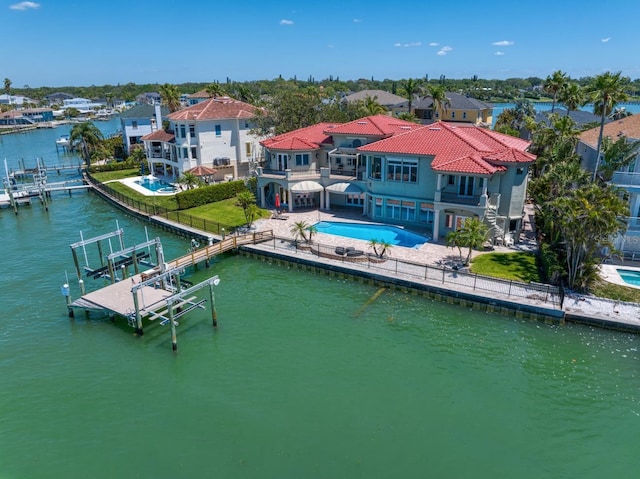 view of dock featuring a patio, a balcony, boat lift, an outdoor pool, and a water view