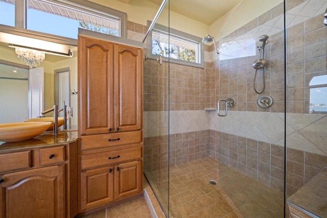 bathroom with a shower stall, a chandelier, and vanity