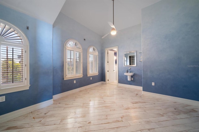 entrance foyer with wood-type flooring, high vaulted ceiling, baseboards, and ceiling fan