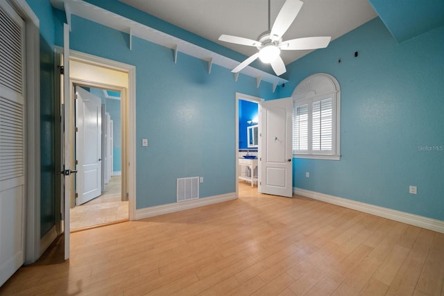 unfurnished bedroom featuring baseboards, wood finished floors, and visible vents