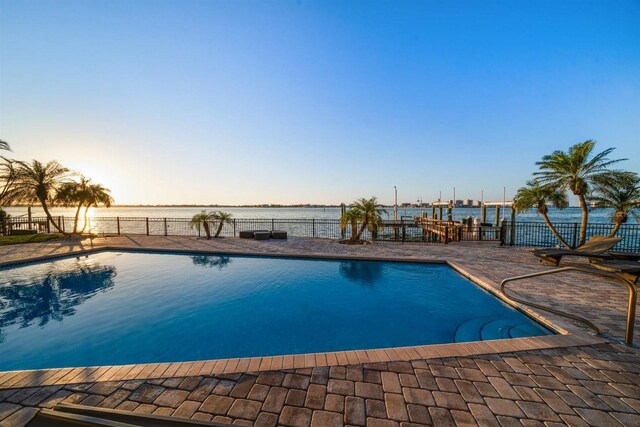 view of pool featuring a fenced in pool, a water view, and fence