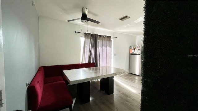 dining space featuring wood-type flooring and ceiling fan