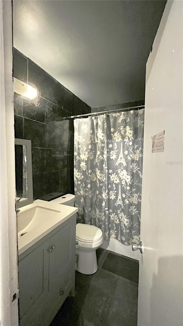 bathroom featuring vanity, tile walls, tile patterned floors, and toilet