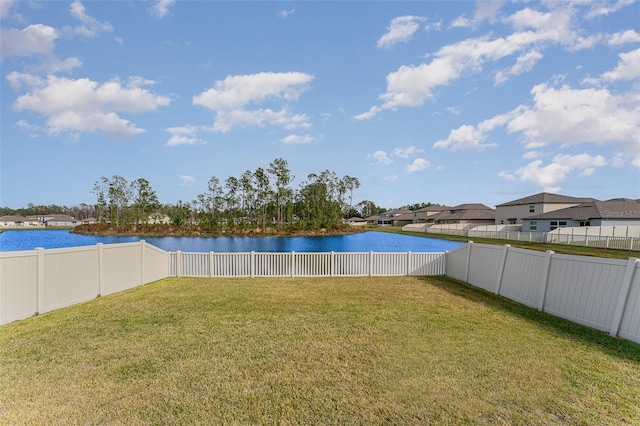 view of yard featuring a water view and a fenced backyard