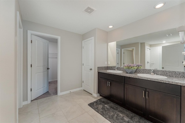 bathroom with tile patterned floors, vanity, and a shower