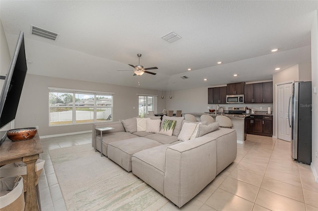 tiled living room featuring sink, vaulted ceiling, and ceiling fan