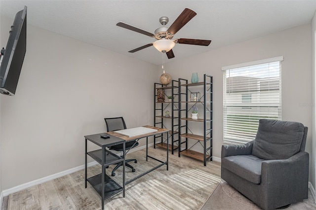 office with baseboards, ceiling fan, and light wood-style floors