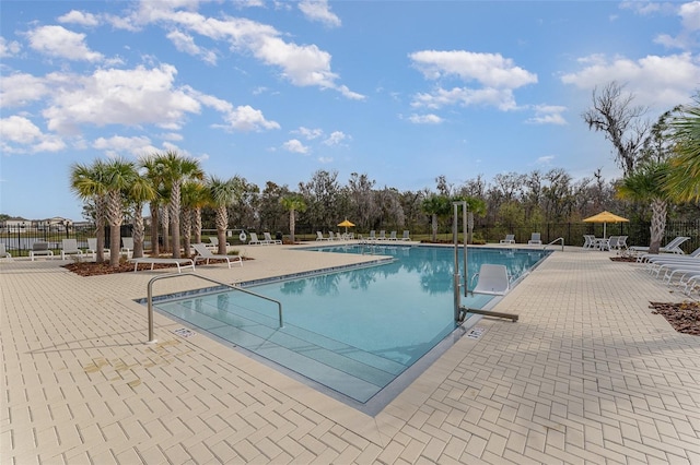 pool with a patio and fence