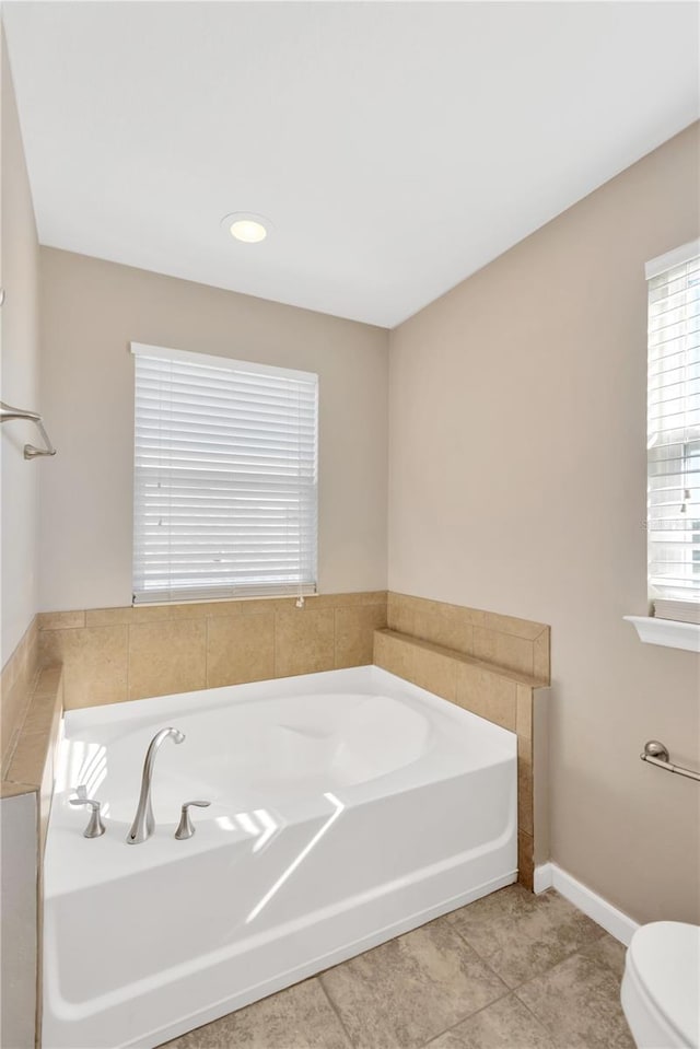 bathroom featuring tile patterned floors, toilet, and a bathing tub