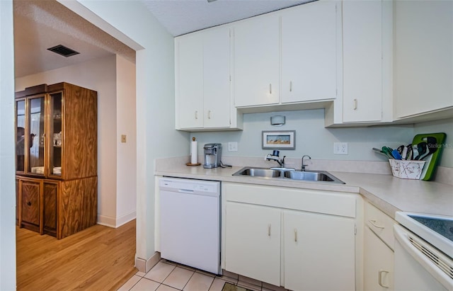 kitchen with white cabinetry, sink, white appliances, and light hardwood / wood-style flooring