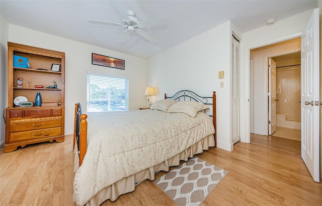 bedroom with ceiling fan, light hardwood / wood-style floors, a closet, and a textured ceiling