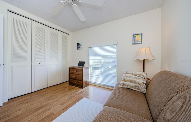 interior space with ceiling fan, a textured ceiling, and light wood-type flooring