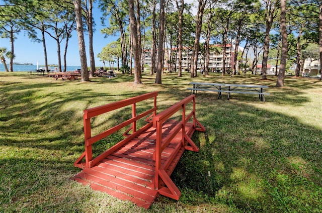 view of property's community with a lawn and a water view