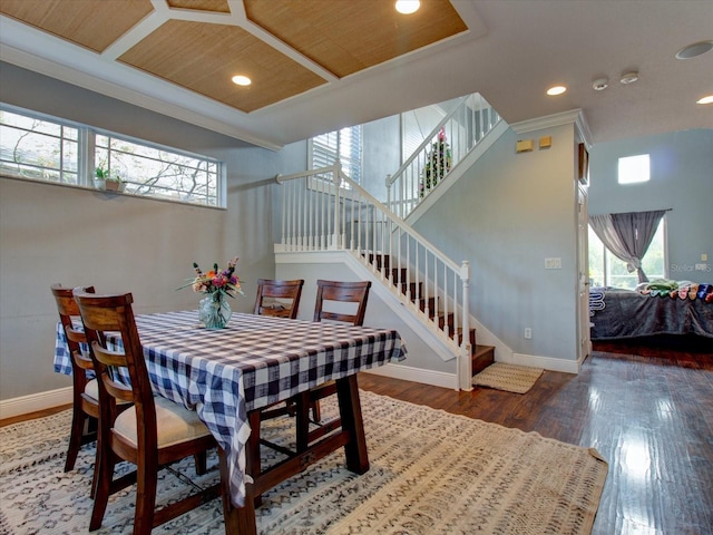 dining area featuring dark hardwood / wood-style flooring, wood ceiling, and a towering ceiling