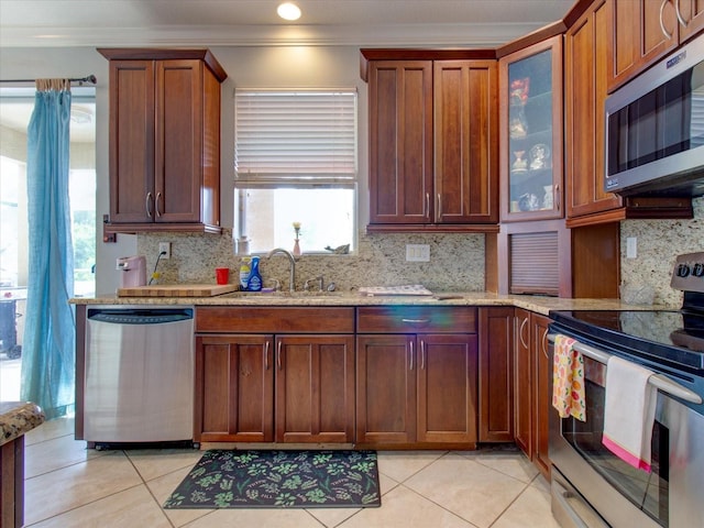 kitchen featuring sink, backsplash, ornamental molding, light tile patterned floors, and stainless steel appliances