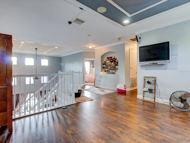 interior space featuring crown molding, a tray ceiling, and dark wood-type flooring